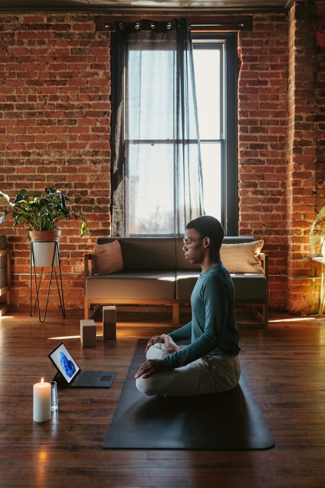 Man sitting on yoga mat in living room